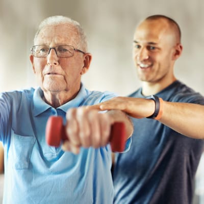 Senior resident exercising with staff guidance
