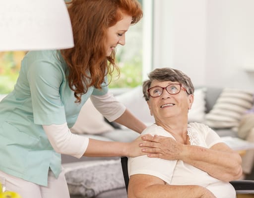 Staff member assisting a smiling resident