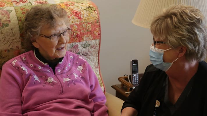 Care staff engaging with a senior resident indoors