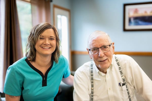 A caregiver and a smiling resident in a bright interior