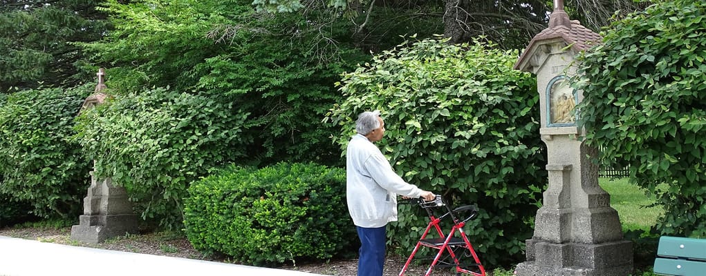 A resident using a walker in a garden area