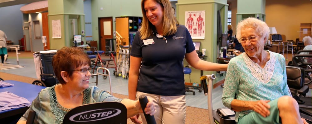 Residents engaging in physical therapy with staff support