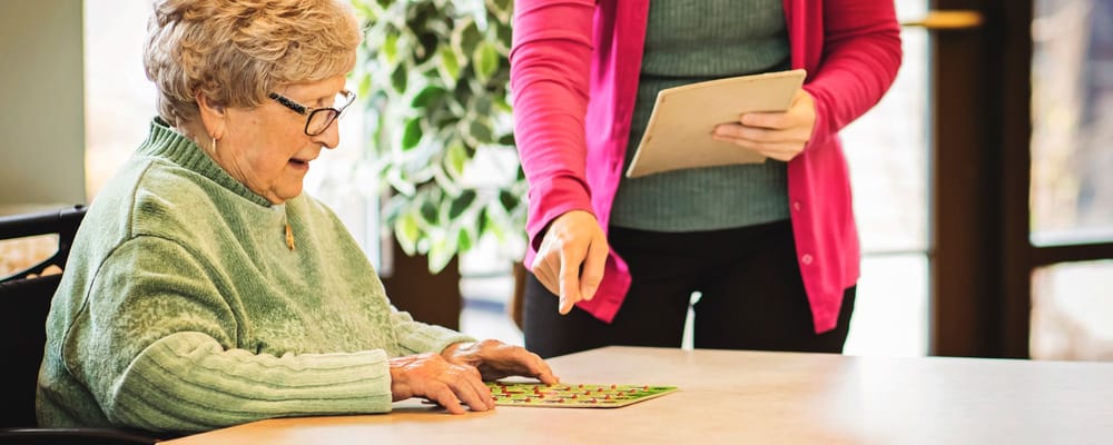 Resident playing bingo with staff support
