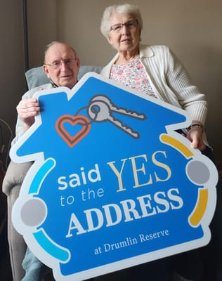 Residents holding a sign celebrating an address milestone