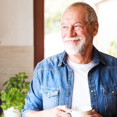Smiling senior man holding a cup