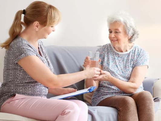 Caregiver assisting a resident with a glass of water