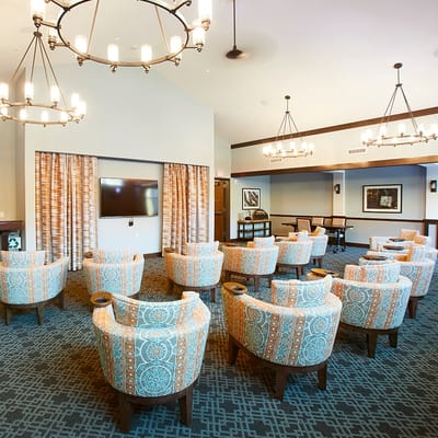 Common area with colorful armchairs and a large screen