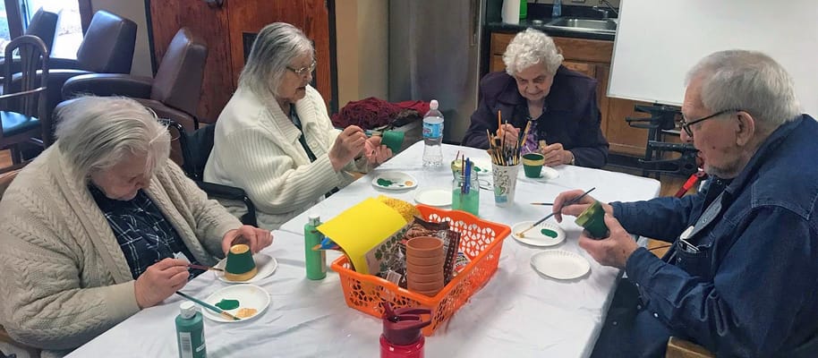 Residents painting pots in a common area activity