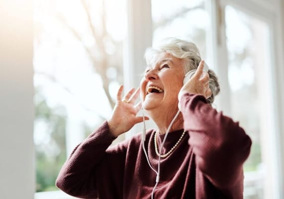 Senior woman joyfully listening to music with headphones