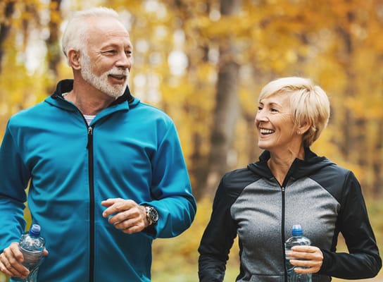 Two seniors enjoying a walk in a forest setting
