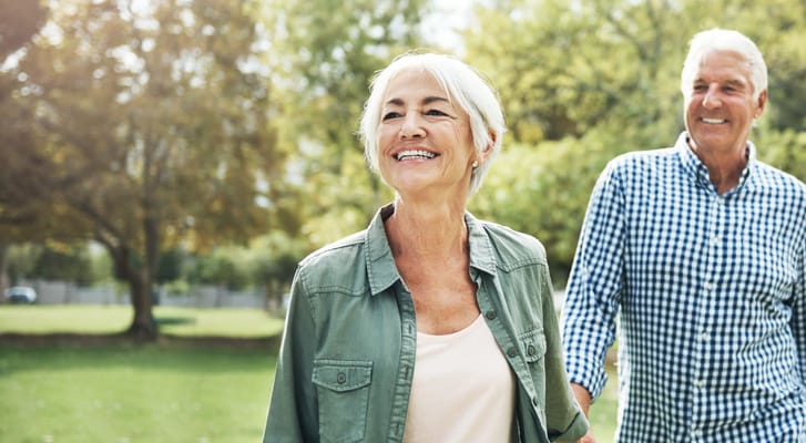 Two seniors walking in a park on a sunny day