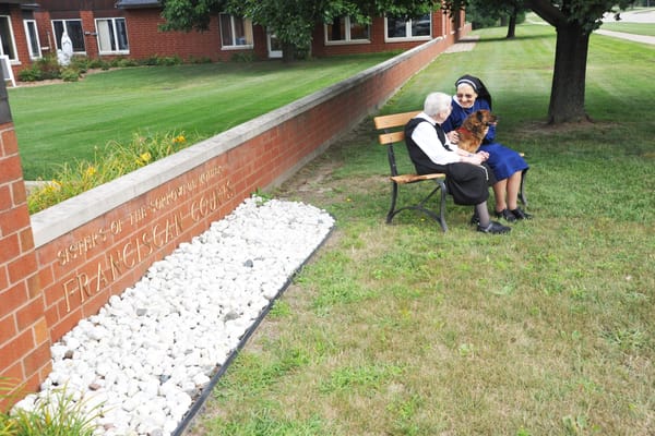 Two residents enjoying time outdoors at Franciscan Courts