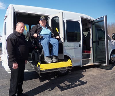 Resident using a wheelchair lift to enter a facility vehicle