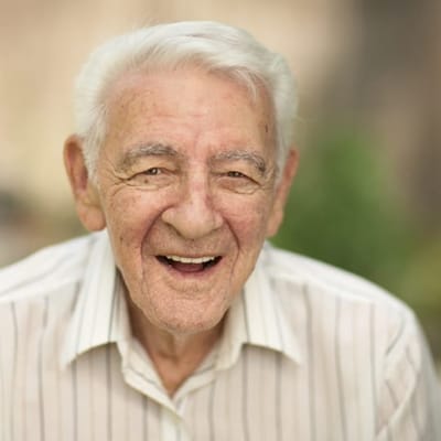 An elderly man smiling warmly