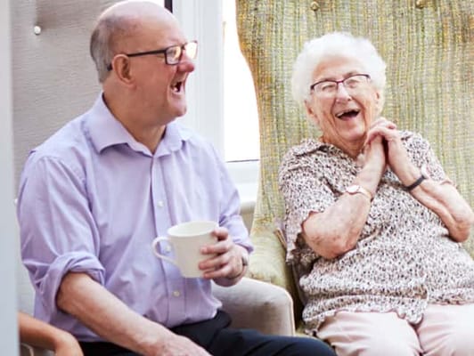 Two residents enjoying a cheerful moment in a common area
