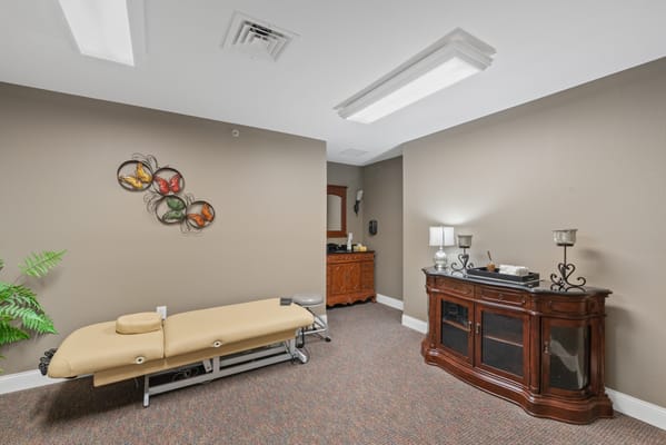 Spa room with massage table and decor.