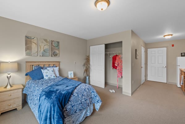 Brightly decorated private resident room with bed and closet