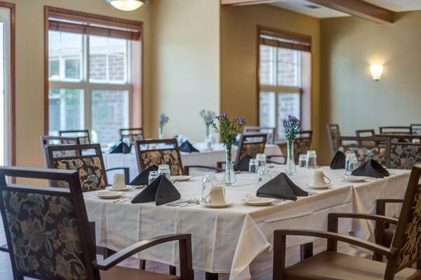 Dining room set for a meal with flowers on the tables