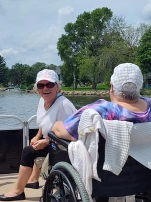 Two smiling residents enjoying the outdoors by the water