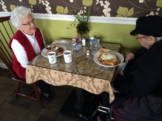 Two residents enjoying a meal at a dining table
