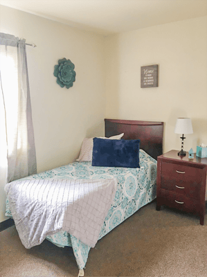 Cozy private room with a bed and bedside table