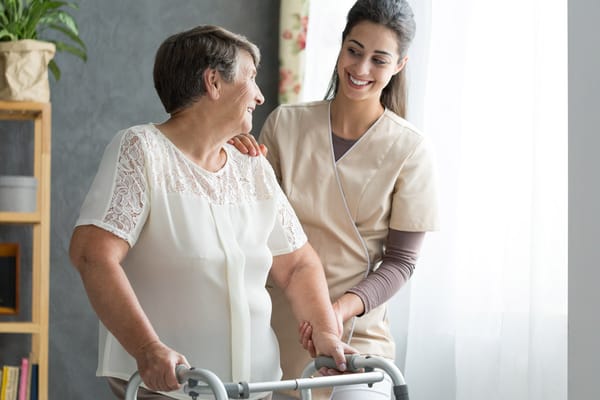 Caregiver assisting a resident with a walker