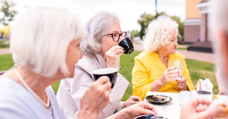 Residents enjoying coffee outside on a sunny day
