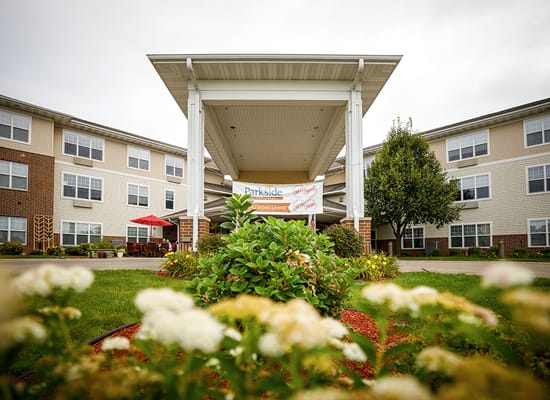 Exterior view of Parkside Assisted Living entrance with landscaping