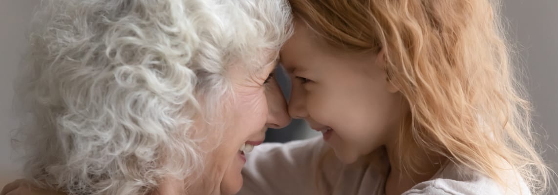A senior woman and a young girl smiling together