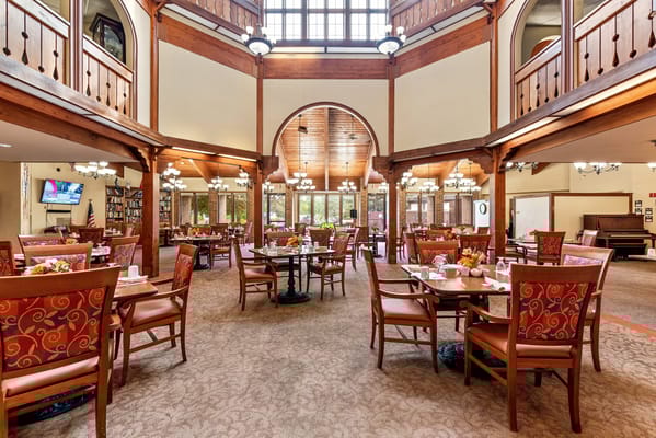 Brightly lit dining room with tables set for meals