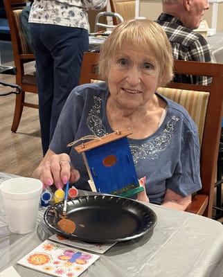 Resident painting a birdhouse during an activity