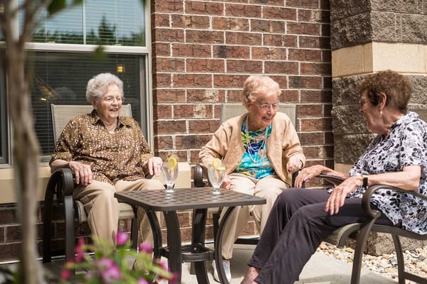 Three residents enjoying drinks in an outdoor space