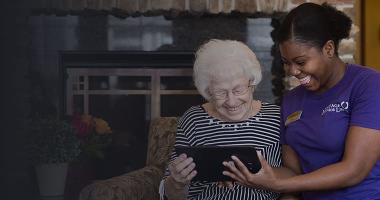 A caregiver and resident enjoying a tablet together