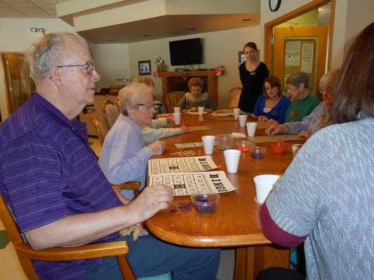 Residents engaging in a bingo game around a table