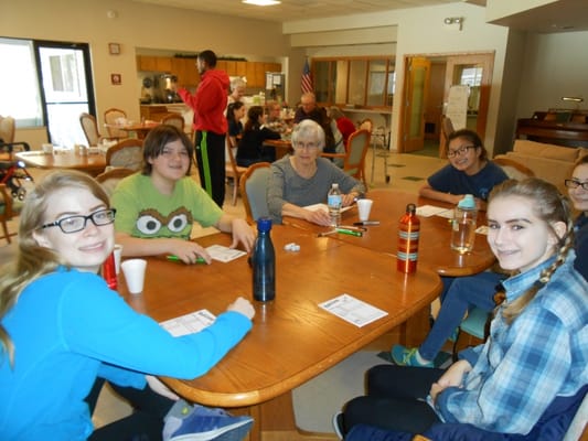 Residents and visitors engaging in an activity at a common area table.