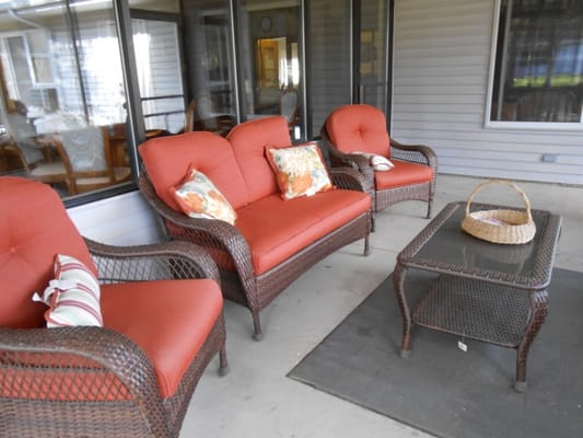 Patio furniture with cushions on a porch