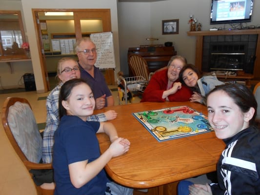 Residents and children playing a board game together