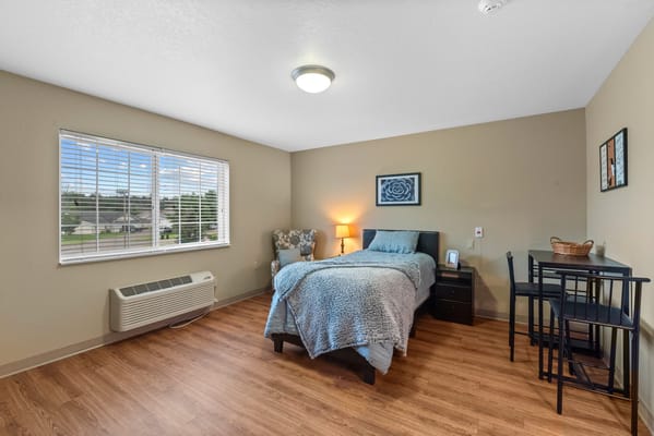 Bright and cozy resident room with a bed and seating area