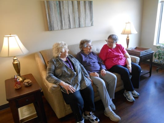 Three residents chatting together on a couch.