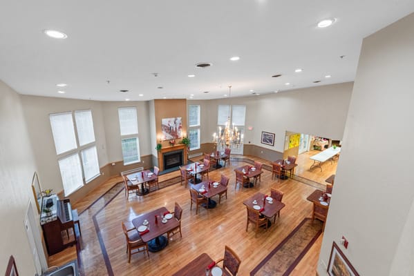 Overview of a bright dining room with tables set for meals.