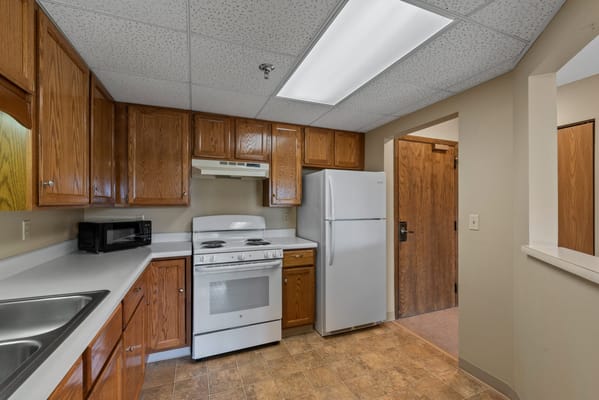 Well-lit kitchen area with wooden cabinetry