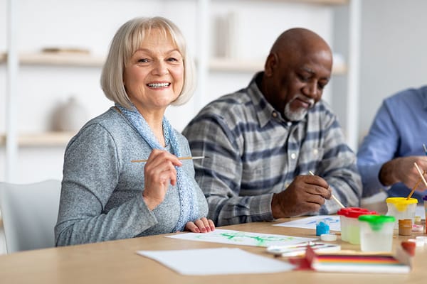 Residents engaged in an art activity at a table