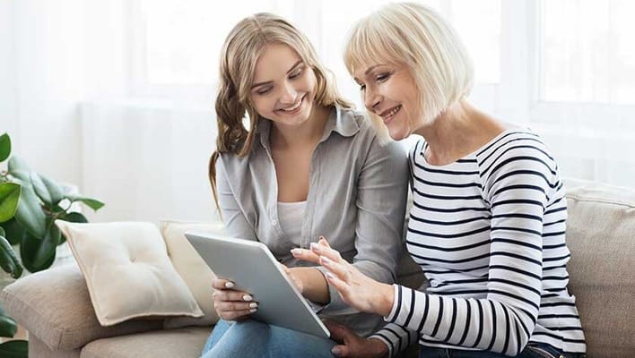 A young woman and a senior woman using a tablet together