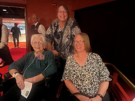 Two residents and a staff member smiling together