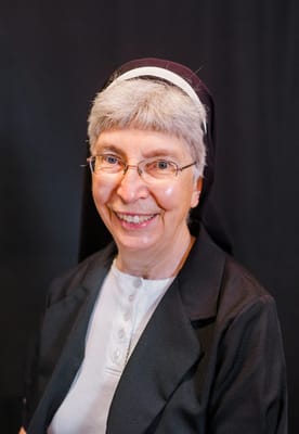 Smiling elderly nun in a black outfit
