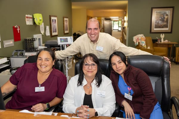 Staff members smiling together at the reception desk