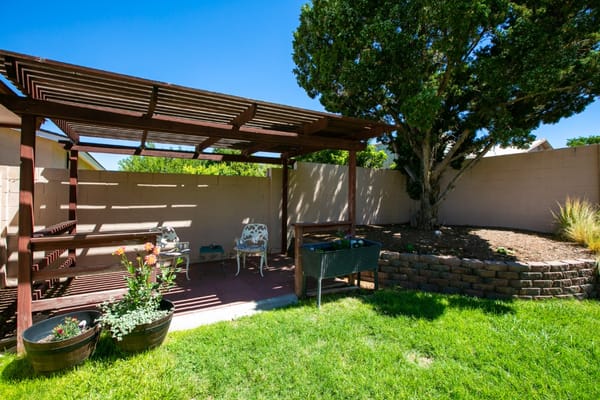 Outdoor seating area with shaded patio and greenery