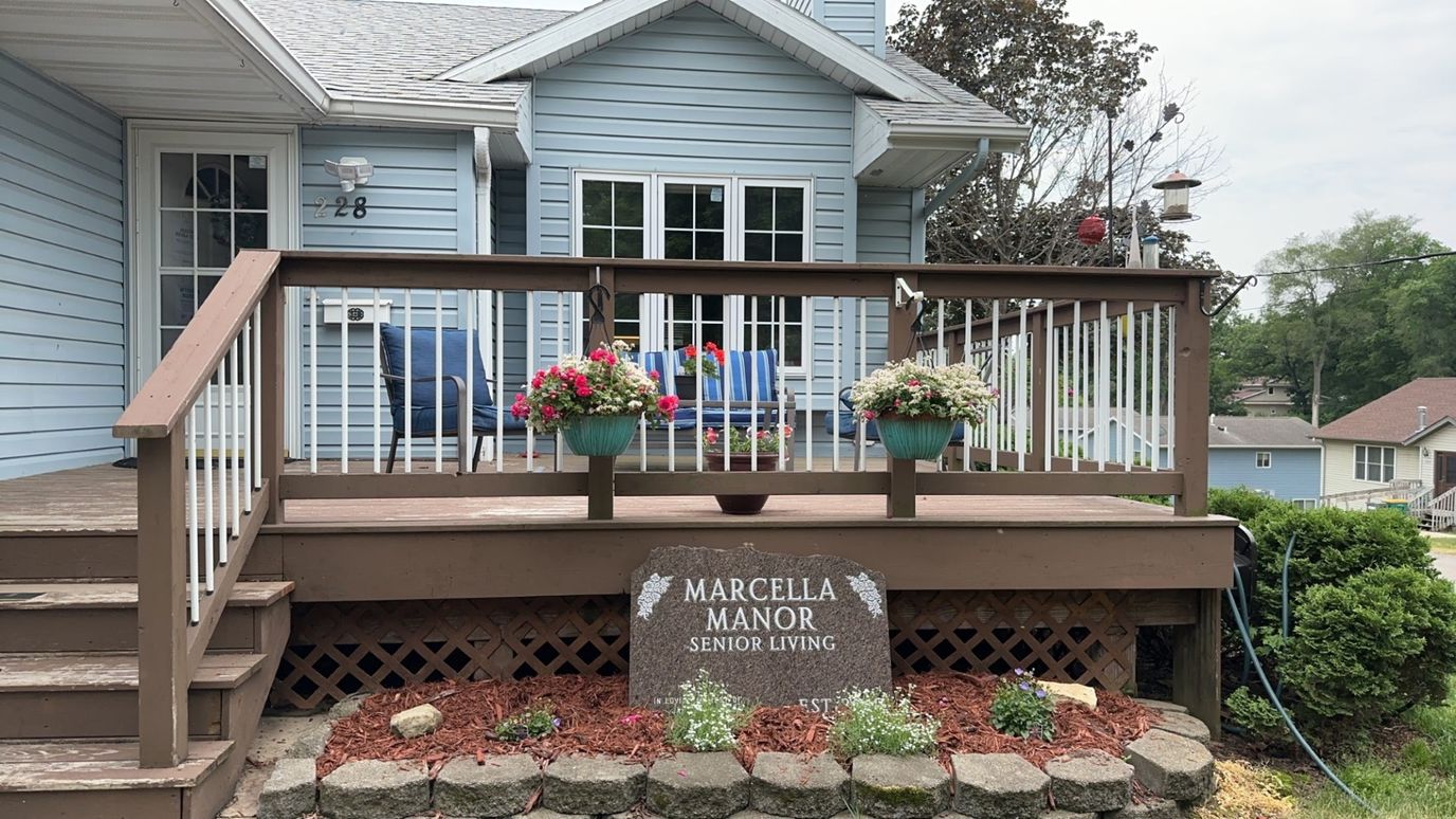 Exterior view of Marcella Manor with flowers and seating
