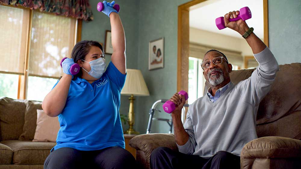 Resident and staff engaging in a fitness activity.