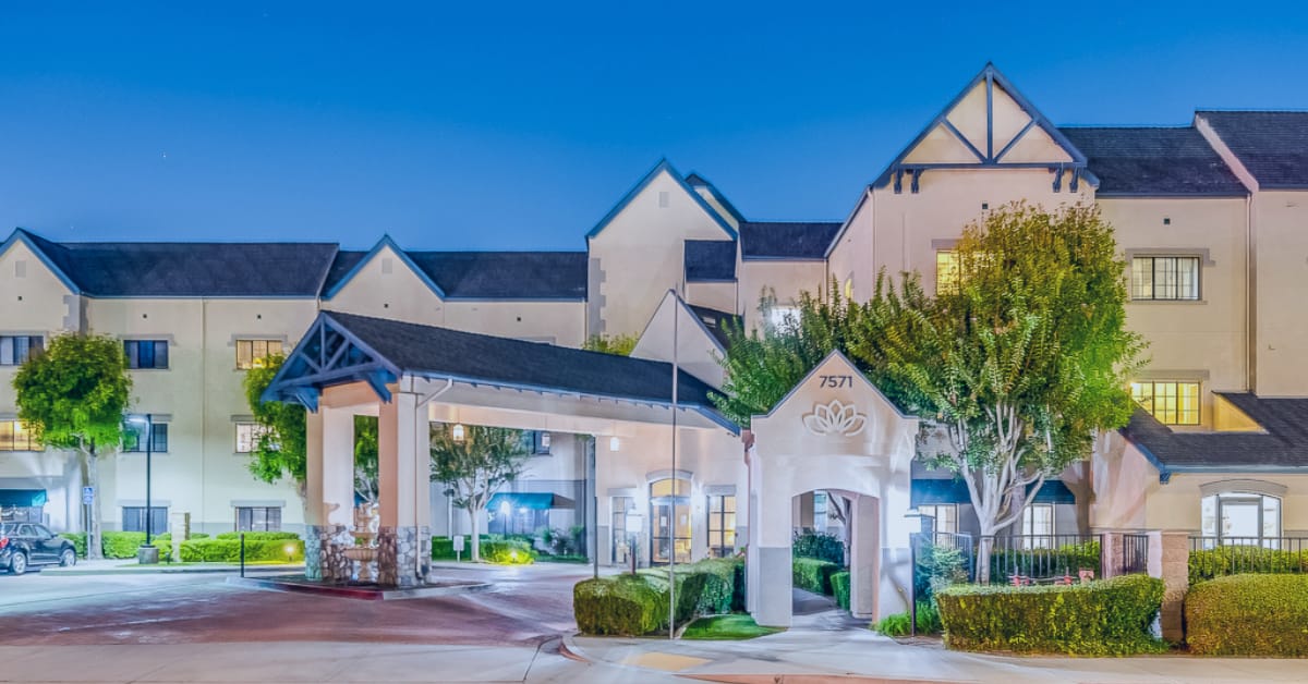 Exterior view of a senior living facility at dusk